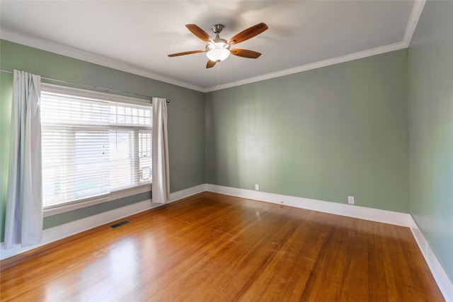 empty room featuring ceiling fan, wood-type flooring, and ornamental molding