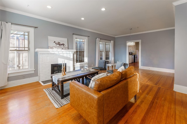 living room featuring a fireplace, hardwood / wood-style floors, and crown molding