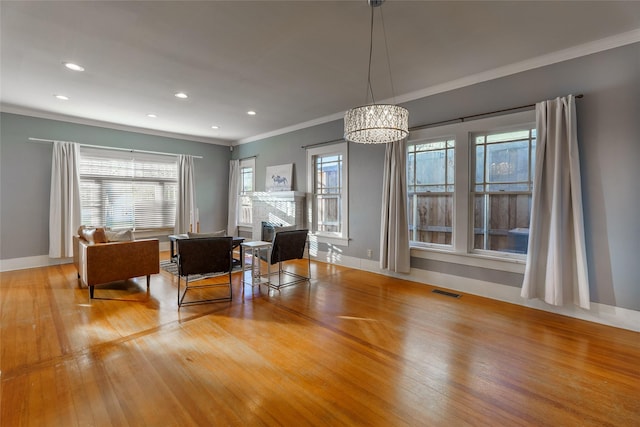 interior space featuring light hardwood / wood-style floors, an inviting chandelier, and crown molding