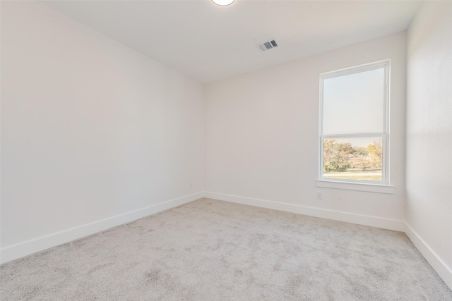 spare room featuring light colored carpet