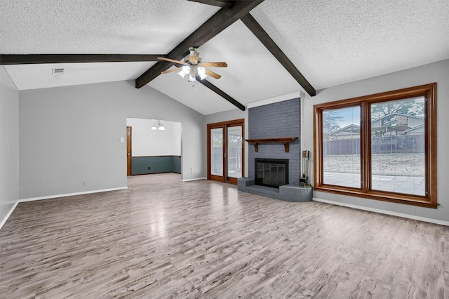 1802 Oak Creek Dr, Sherman, TX 75092 - unfurnished living room featuring wood finished floors, plenty of natural light, a ceiling fan, a textured ceiling, and a fireplace