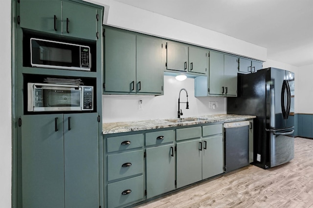 kitchen featuring sink, light hardwood / wood-style flooring, stainless steel appliances, and light stone countertops