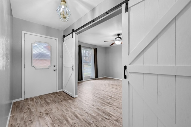 foyer with a barn door and light hardwood / wood-style floors