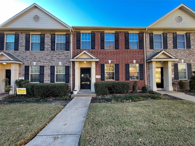 townhome / multi-family property featuring a front lawn