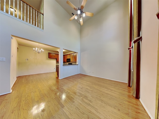4133 Kyndra Cir, Richardson, TX 75082 - unfurnished living room featuring light wood-type flooring, baseboards, high vaulted ceiling, and ceiling fan with notable chandelier