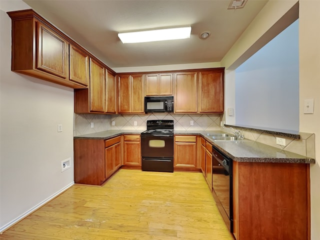 4133 Kyndra Cir, Richardson, TX 75082 - kitchen featuring black appliances, dark countertops, light wood-style flooring, and a sink