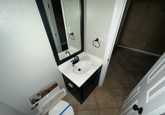 bathroom with tile patterned flooring, vanity, and toilet