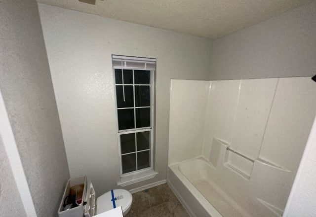 bathroom featuring toilet and shower / bath combination