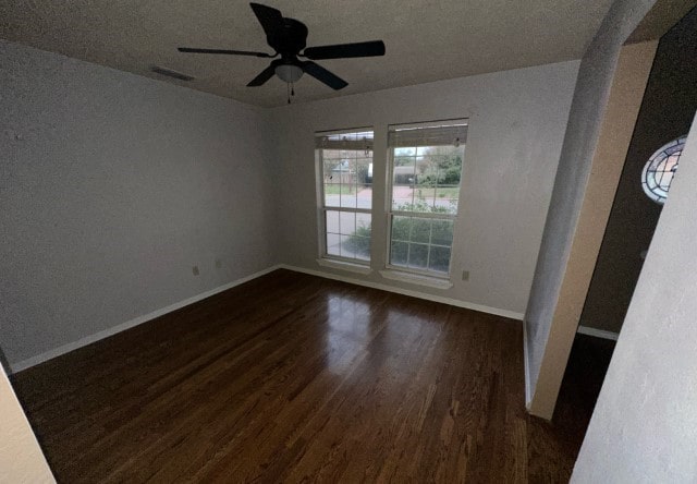 unfurnished room with ceiling fan, dark hardwood / wood-style flooring, and a textured ceiling