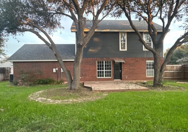 back of property featuring a lawn, central air condition unit, and a patio