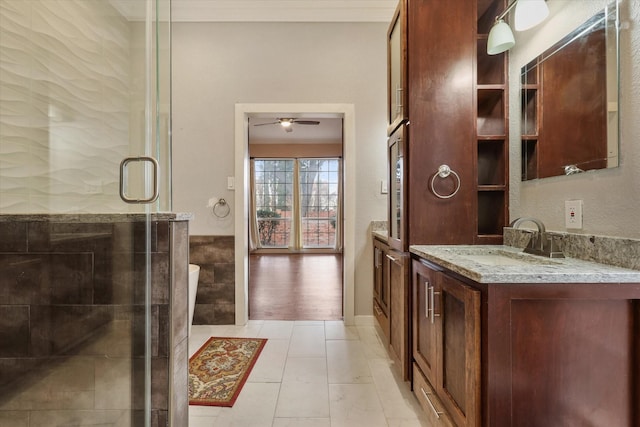 bathroom featuring a shower with door, ceiling fan, vanity, ornamental molding, and tile patterned floors