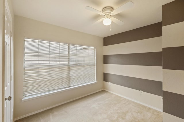 carpeted spare room with ceiling fan