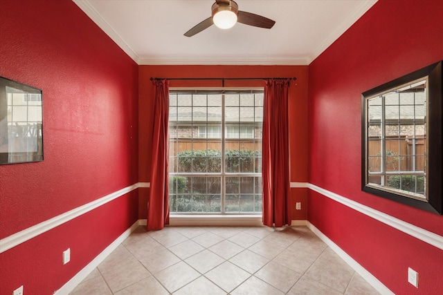 tiled spare room featuring ceiling fan, ornamental molding, and a wealth of natural light