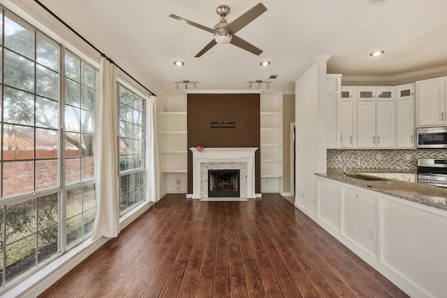 interior space with sink, light stone counters, white cabinetry, dark hardwood / wood-style floors, and stainless steel appliances