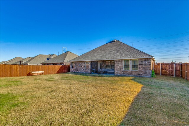 rear view of property with a lawn