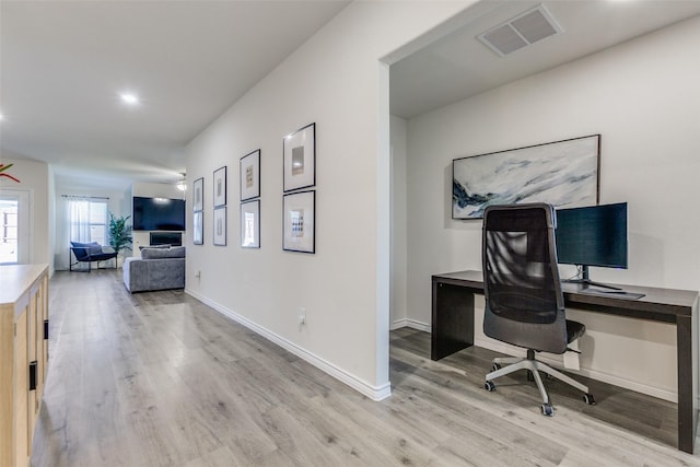 home office with light hardwood / wood-style floors