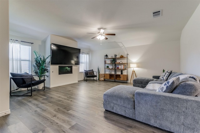 living room featuring wood-type flooring and ceiling fan