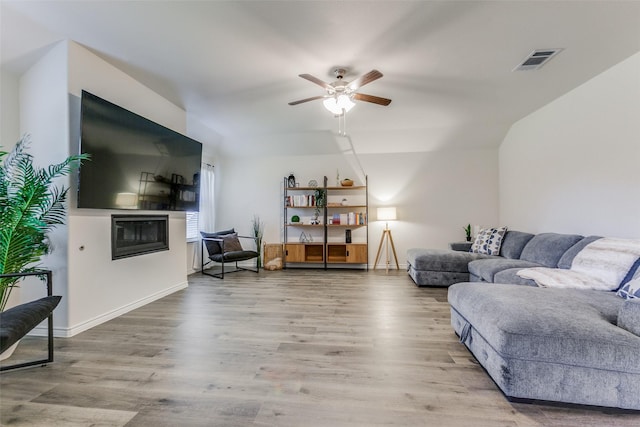 living room featuring hardwood / wood-style flooring, vaulted ceiling, and ceiling fan