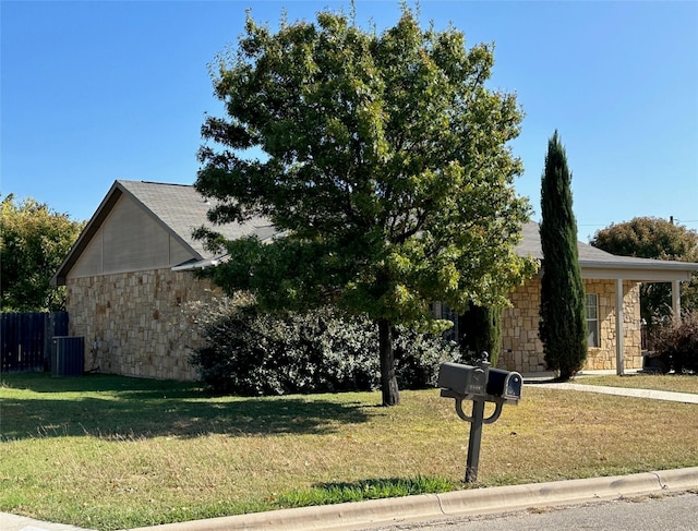 view of side of home featuring a yard and central AC unit