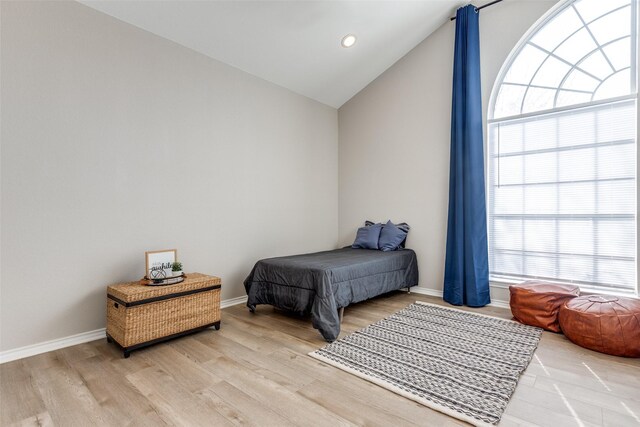 bedroom featuring lofted ceiling and light hardwood / wood-style flooring