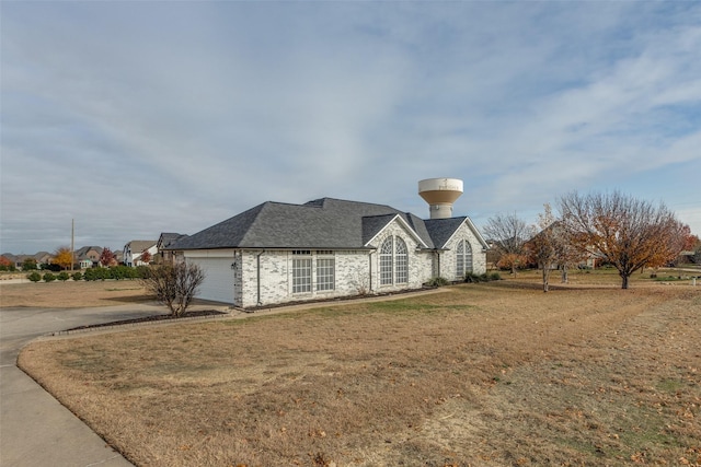 view of side of property with a yard and a garage