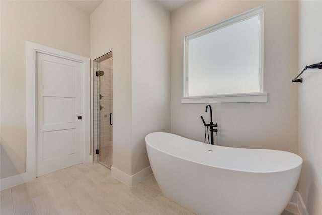 bathroom featuring wood-type flooring and separate shower and tub