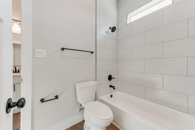 bathroom with tiled shower / bath combo and toilet