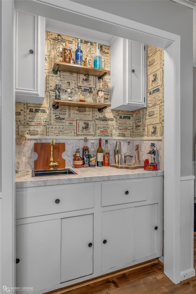 bar with white cabinetry and hardwood / wood-style flooring