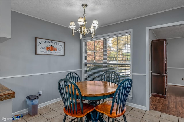 tiled dining room with crown molding, a chandelier, and a textured ceiling