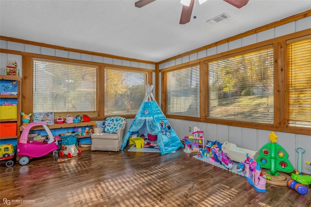 game room with hardwood / wood-style flooring, ceiling fan, and a textured ceiling