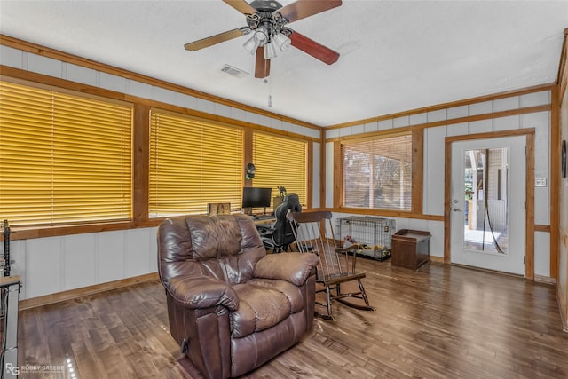 sitting room featuring wood-type flooring, ornamental molding, radiator, and ceiling fan