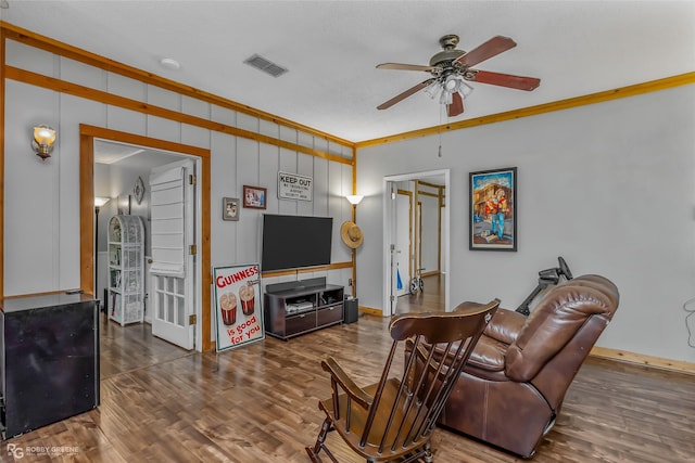 living room featuring crown molding, ceiling fan, and dark wood-type flooring