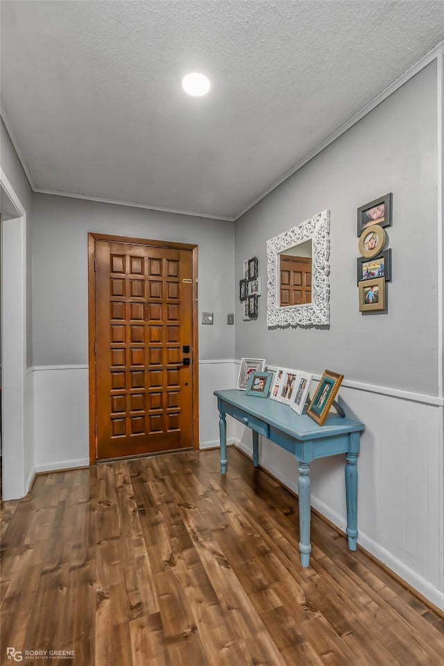 entrance foyer with dark hardwood / wood-style flooring, crown molding, and a textured ceiling