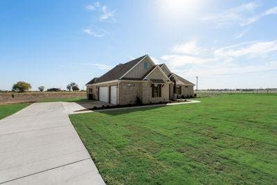 view of side of property featuring a yard and a garage