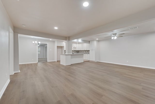 unfurnished living room featuring light hardwood / wood-style floors and ceiling fan with notable chandelier