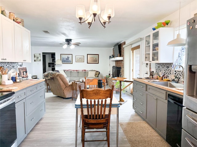 kitchen with dishwasher, light wood finished floors, a sink, and gray cabinetry