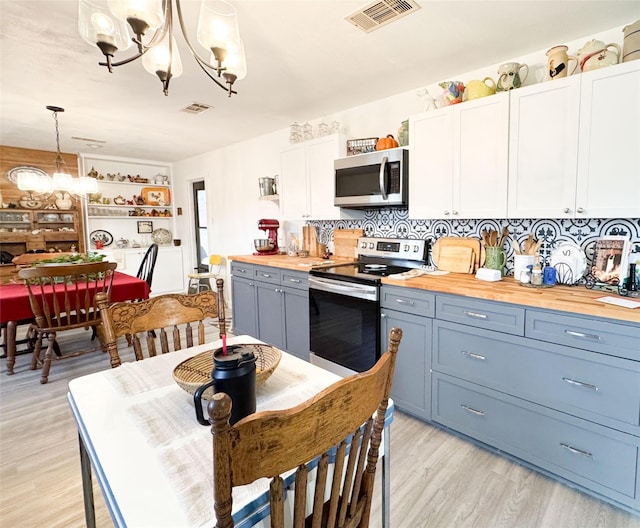 kitchen with backsplash, stainless steel appliances, pendant lighting, light hardwood / wood-style floors, and white cabinetry