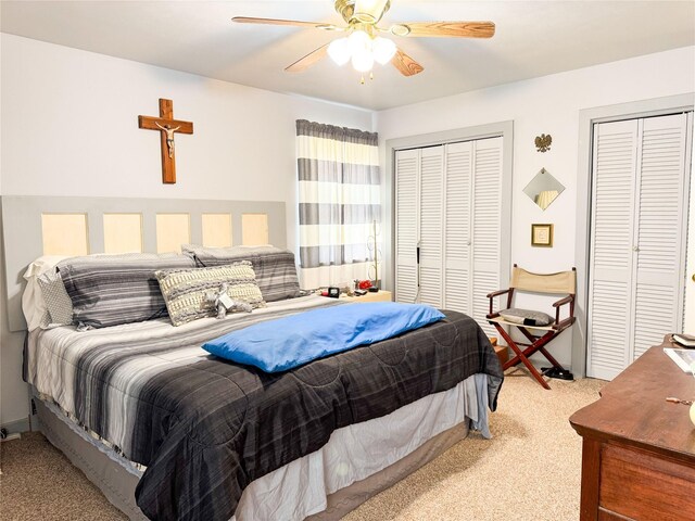 carpeted bedroom with two closets and ceiling fan