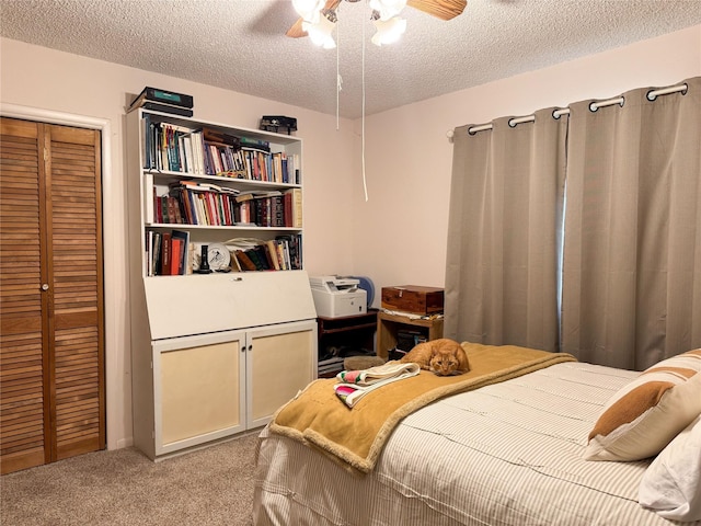 bedroom featuring carpet floors, a textured ceiling, a ceiling fan, and a closet