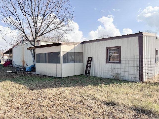 exterior space featuring a yard and a sunroom