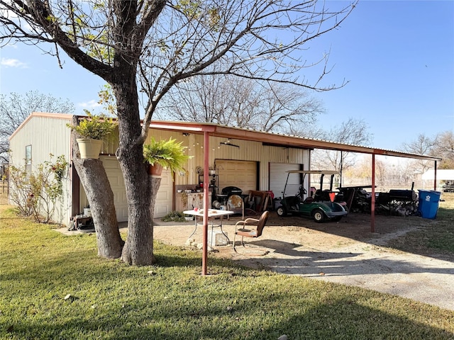 view of outbuilding featuring a lawn, a carport, and a garage