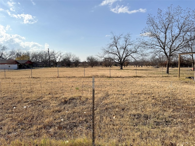 view of yard featuring a rural view and fence