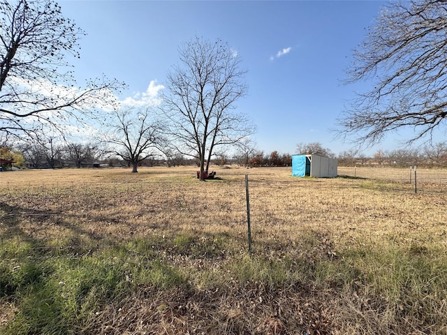 view of yard featuring a rural view and an outdoor structure