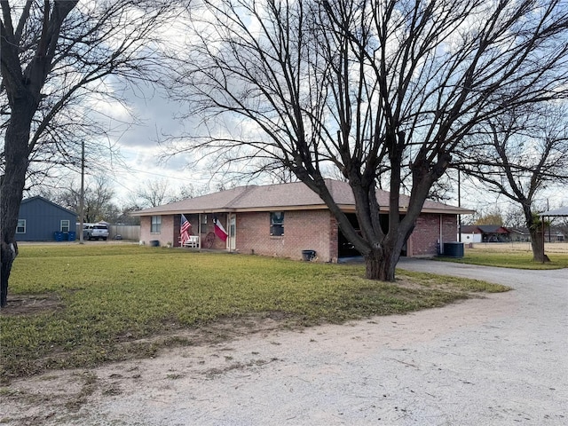 single story home with central air condition unit, a front lawn, and brick siding