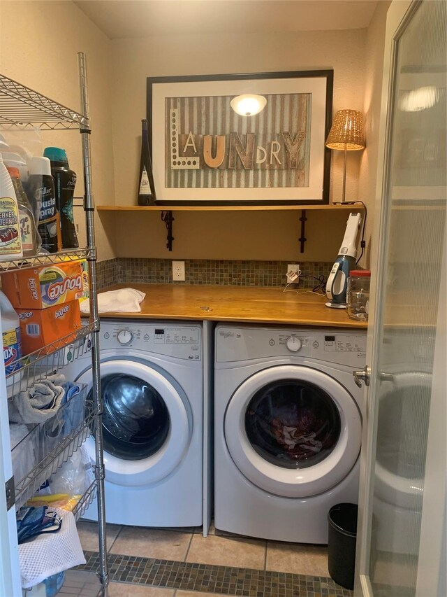 clothes washing area featuring washing machine and dryer and light tile patterned floors