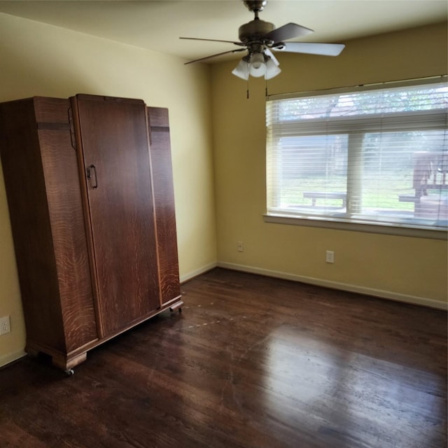 unfurnished bedroom featuring ceiling fan and dark hardwood / wood-style floors