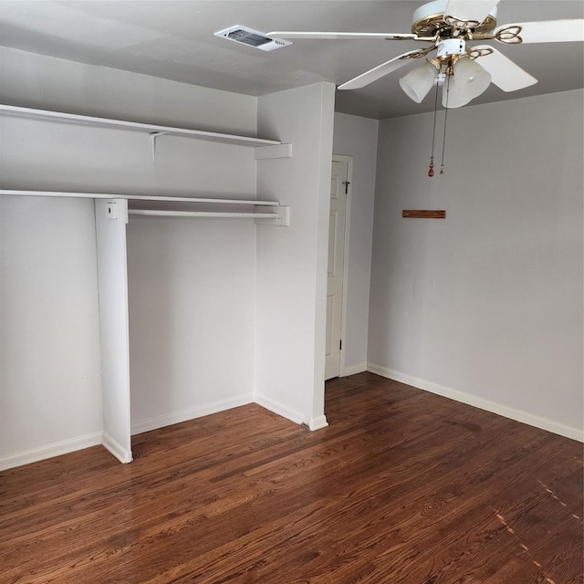 unfurnished bedroom with dark wood-type flooring, ceiling fan, and a closet