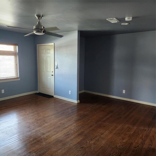 unfurnished room featuring dark wood-type flooring and ceiling fan