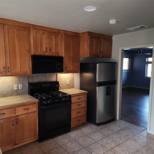 kitchen featuring light tile patterned flooring and black appliances