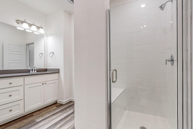 bathroom with vanity, an enclosed shower, and hardwood / wood-style floors